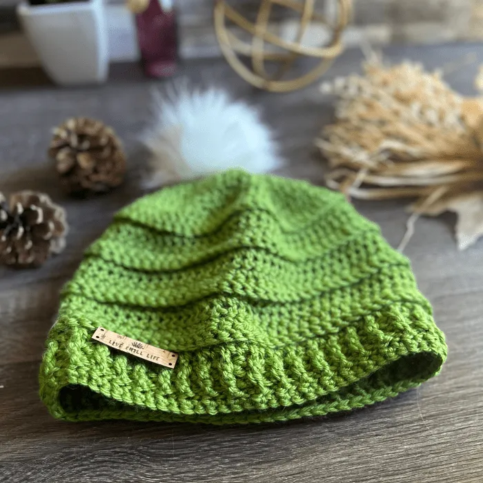 green crochet hat with fur pom pom