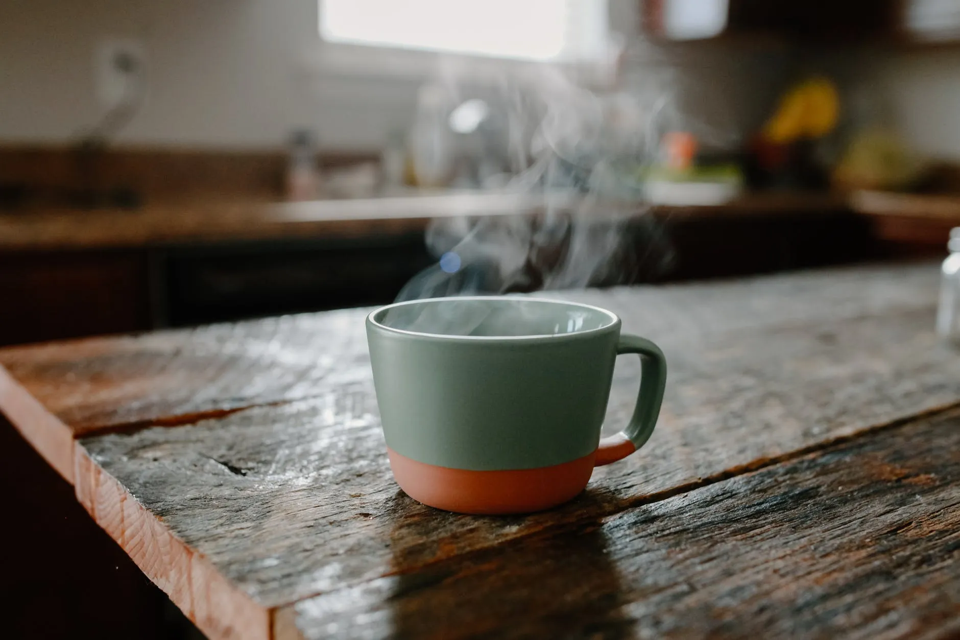 close up photo of a green cup with a hot drink