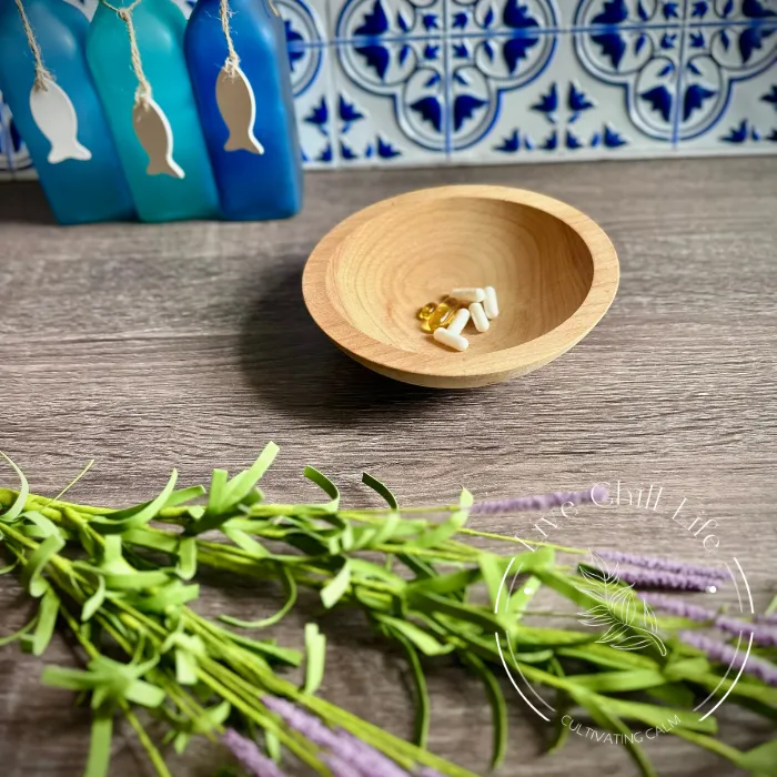 supplements in a wood dish with a sprig of lavender