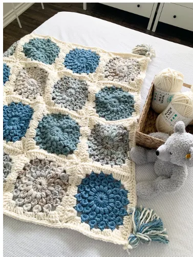 large granny square blanket in off white and shades of blue