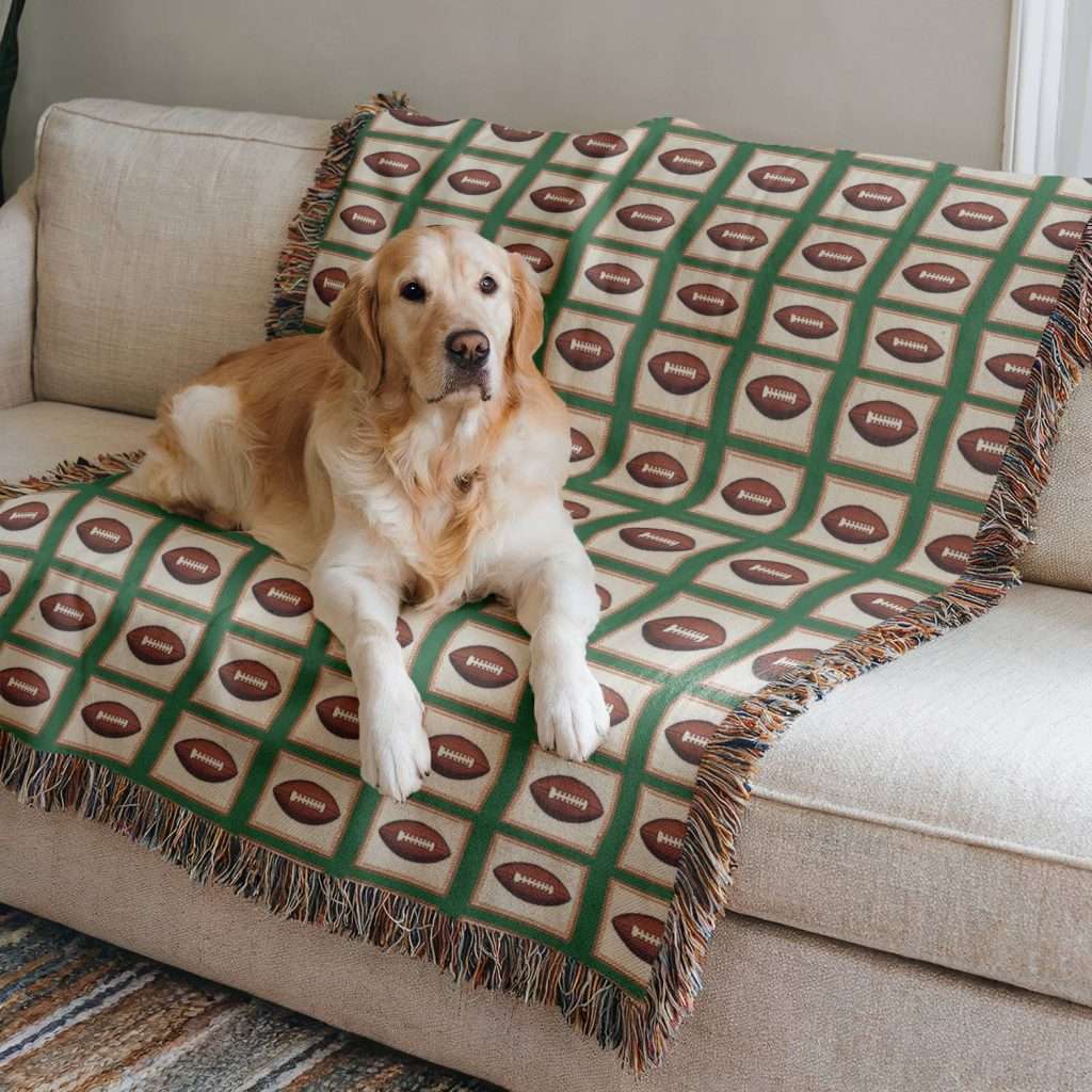 Football blanekt on a sofa with a golden retriever dog resting happily on it