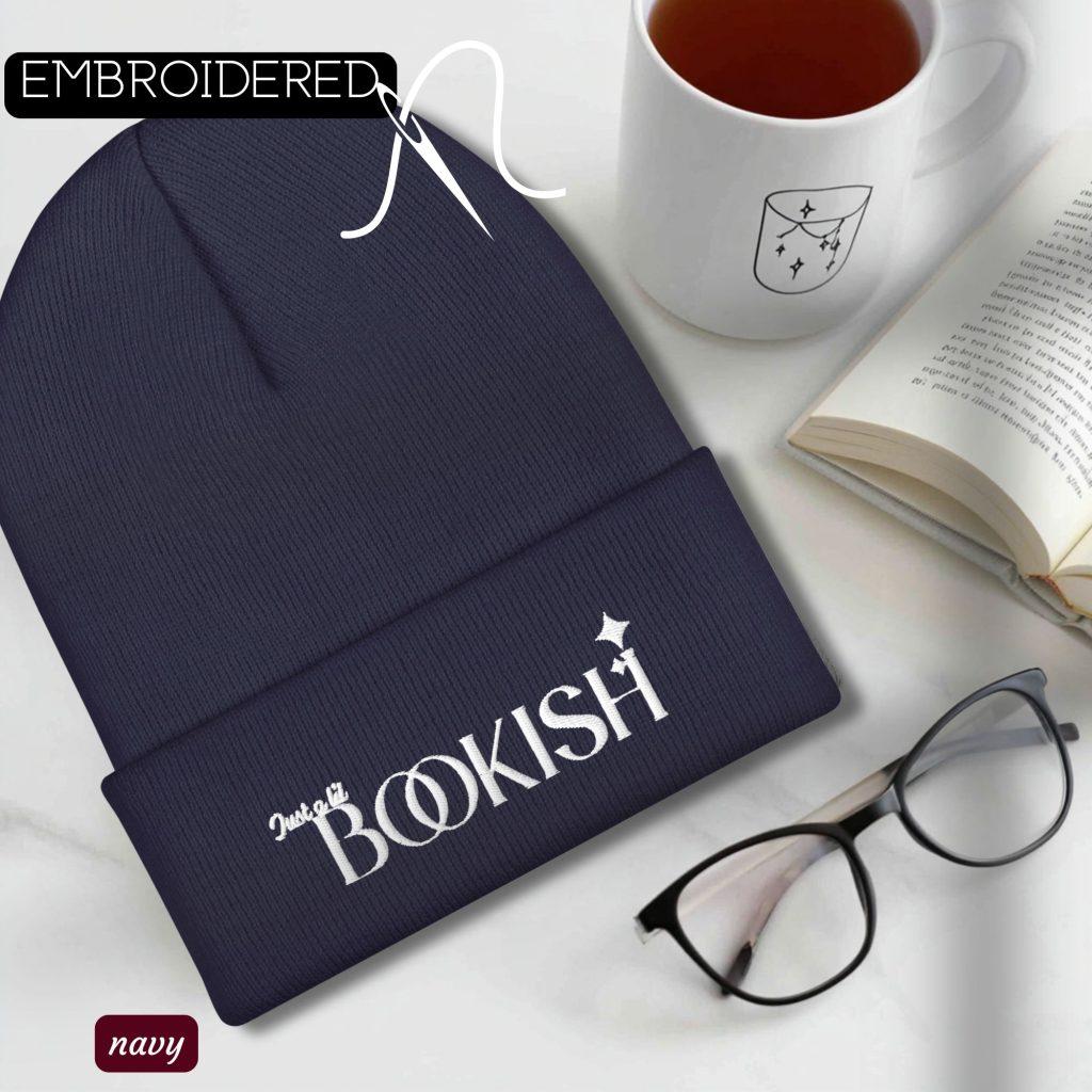 knit hat embroidered with "bookisH', flat lay on a table great for a cozy book lover gift