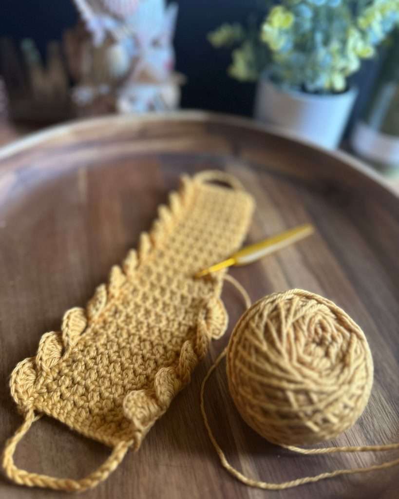 yellow yarn in a wood dish with a crochet hook