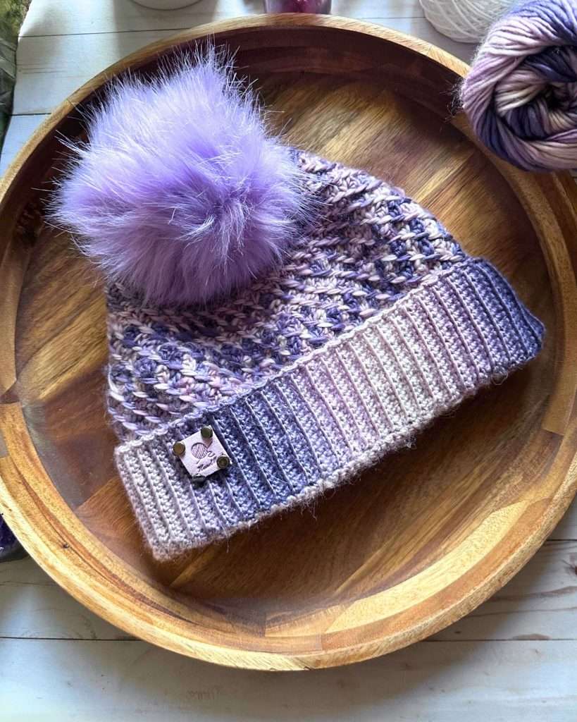 spiral crochet hat in a purple gradient with a purple fur topper