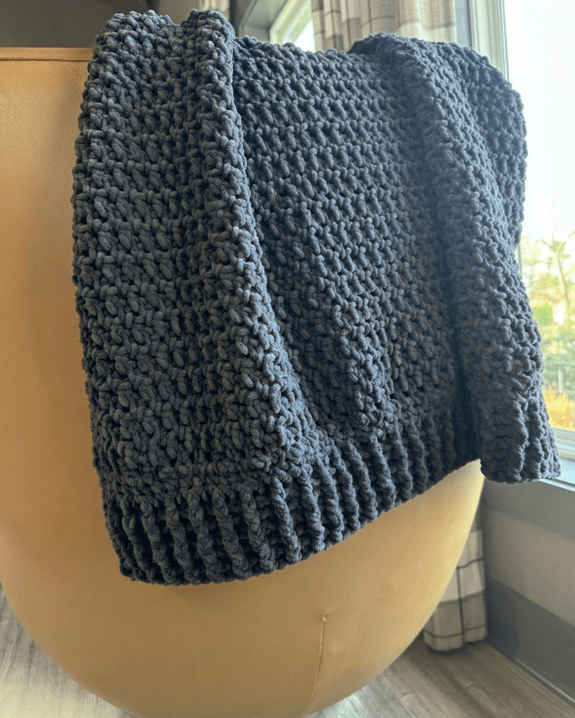 Chunky chenille crochet blanket made with charcoal gray yarn